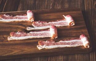 Bacon strips on the wooden board photo