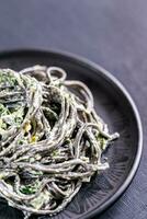 Black pasta with spinach, mascarpone and Parmesan photo