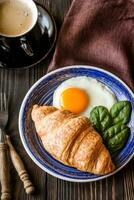 frito huevo con cuerno y un taza de café foto