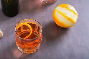 Cold cocktail Negroni Sbagliato with liqueur, vermouth and orange in glasses on the table photo