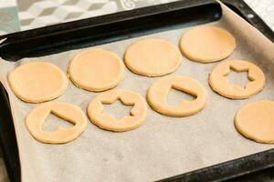 Uncooked Linzer cookies on a baking sheet, ready to bake. Cooking Christmas treats. Lifestyle photo