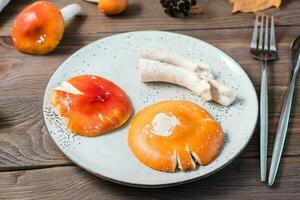 Raw chopped ready-to-eat amanita on a plate on a wooden table. Microdosing and Alternative Medicine. Close-up photo