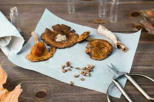 Dried chopped amanita ready to eat on parchment and scissors on a wooden table. Microdosing and Alternative Medicine. photo