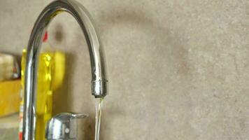 water pouring from a faucet tap slow motion . video