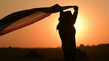 lento movimiento imágenes de caucásico americano vaquero patriota corriendo con bandera durante 4to de julio independencia día puesta de sol. video
