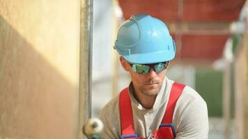 Caucasian Construction Worker in Blue Hard Hat on a Scaffolding Doing His Job. video