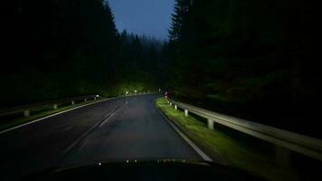 coche exceso de velocidad abajo el carretera. bosque la carretera en tarde noche horas. la carretera iluminación video