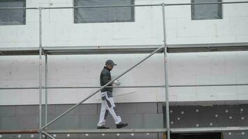 caucásico construcción trabajador con bloquear de pared aislamiento video