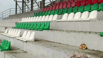 Krieg im Ukraine. gebrochen Plastik Bänke zum Fans auf das Podium, im ein zerstört Fußball Stadion im ein Kinder- Fußball Schule. das Konsequenzen von Beschuss von Artillerie. video