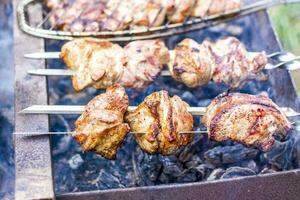 Cooking a barbecue on the fire. Traditional Caucasian kebab on a skewer, cooking meat on skewers. photo