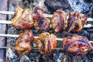 Cocinando un parilla en el fuego. tradicional caucásico brocheta en un brocheta, Cocinando carne en brochetas foto