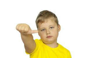 A boy in a yellow T-shirt on a white background points his fingers at a neutral rating. The concept of a banner with information. Space for the text. photo