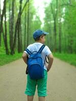 el chico es de viaje con un mochila en su atrás. foto