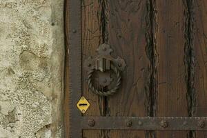 arquitectónico elementos de el pared. antecedentes de cerca de un grunge metal encargarse de en un antiguo hierro puerta. un antiguo puerta con Cerraduras y oxidado manejas. foto