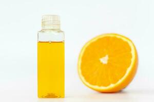 naranja petróleo para el cuerpo. cortar naranja en un blanco antecedentes. orgánico spa productos cosméticos con herbario ingredientes. foto
