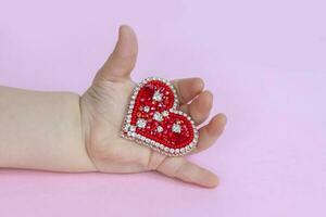 rojo corazón en el palma de tu mano. el concepto de el San Valentín día tema. un saludo tarjeta, un declaración de amor. foto