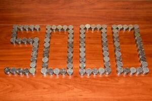 Moscow, 2012-10-15, Five thousand rubles are laid out on the table with the figure of 5000 five-ruble coins. photo