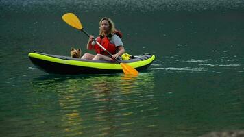 mujer con perro en el kayac en el lago viaje video