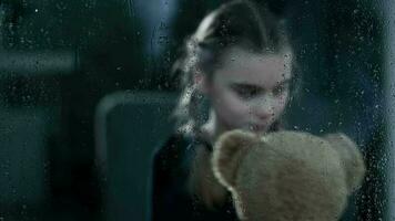 Caucasian Girl Hugs Teddy Bear During Rain. video