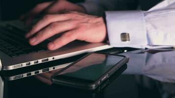 Caucasian Men Working in His Office Let Hours. Smartphone and Laptop Devices in Use. video