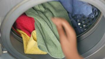 Man putting shirt into washing machine video