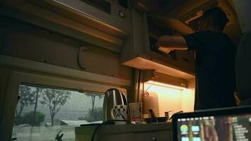 Men Preparing Hot Tea Inside His RV Camper Van During Rainy Day video