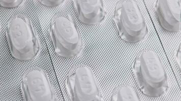 white tablet oval tablets blisters close-up looped spinning or rotating macro background video