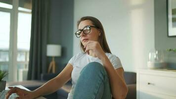 mine de rien habillé femme avec écouteurs travail avec une ordinateur et téléphone intelligent à Accueil dans une confortable environnement. éloigné travail video