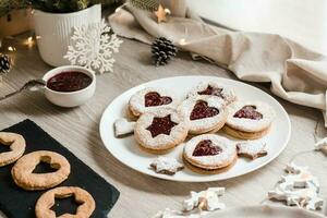 Making Linzer cookies with berry jam on the kitchen table. Christmas treats. Lifestyle photo