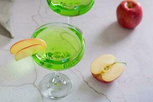 Refreshing apple martini with fruit in glasses on the table photo