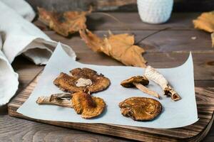 Dried fly agarics on parchment on a wooden table. Microdosing and Alternative Medicine. Close-up photo