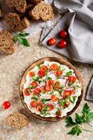 Trendy butter board with tomatoes, onions and parsley and slices of bread top and vertical view photo