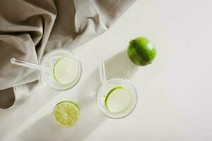 Sparkling mineral water with ice and lime in glasses for refreshment in the summer heat top view photo
