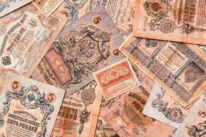 Chaotically scattered old worn ruble banknotes of royal russia. Top view photo