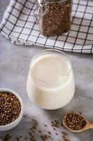 lactosa gratis dietético alforfón Leche en un vaso y semillas en un cuenco en el mesa vertical ver foto