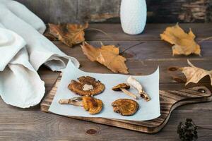 Dried fly agarics on parchment on a wooden table. Microdosing and Alternative Medicine. photo