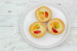 Small fruit pia cake on a textured white background. Kue Pia Buah. photo