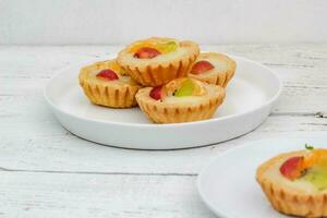 Small fruit pia cake on a textured white background. Kue Pia Buah. photo