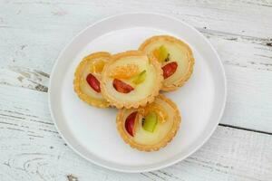 Small fruit pia cake on a textured white background. Kue Pia Buah. photo