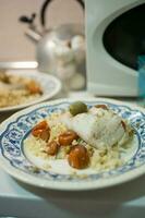 Delicious dish with rice, hake, cherry tomatoes and green olive photo