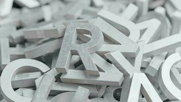 full frame close-up looped slowly rotating background of silver metal letters with selective focus video