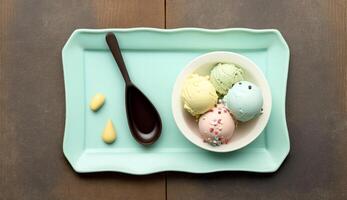 Top view of colorful ice cream in bowl on blue wooden background, photo