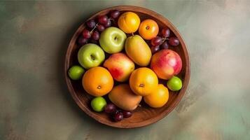 Fruits in a wooden bowl on a green background. Top view, photo