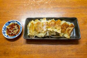 Japanese dumpling or Gyoza on the white plate with soy sauce photo