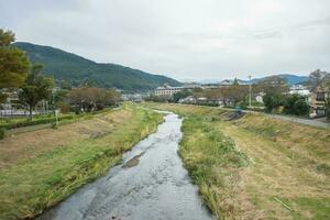 Yufuin village, river, Yufu mountain and blue sky with cloud background, Yufuin, Oita, Kyushu, Japan photo