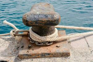 Rusty metal mooring bollard for big ship photo