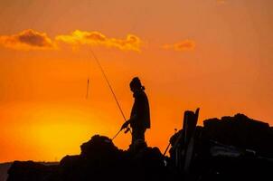 Silhouette of fishing rod photo