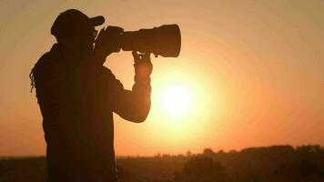 hombres tomando imágenes utilizando digital cámara durante escénico puesta de sol. lento movimiento imágenes video