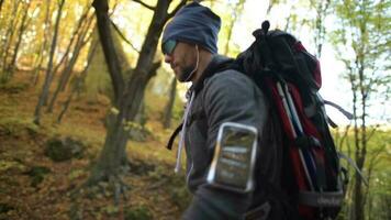 caucasico escursionista con cuffie su un' escursione nel il panoramico foresta. video