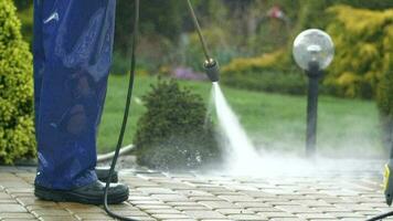 Slow Motion Footage of Men Washing Garden Paths Using Power Washer. video